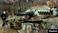 1999'daki Kosova Savaşı'ndan iki yıl sonra (eski) Yugoslav ordusuna ait tank enkazı çevresinde oyun oynayan bir Arnavut çocuk. Genç askerlerde görülen kanser vakaları aynı zamanda "Balkan Sendromu" olarak da adlandırıldı. 1999'da Sırbistan'a karşı yürütülen harekatta NATO jetlerinin 31 binin üzerinde inceltilmiş uranyum içeren mermi kullandığı bildiriliyor. Aynı şekilde 10 bin kadar merminin de 1994-95 yıllarında NATO uçaklarının Bosna'ya müdahalesi sırasında kullanıldığı kaydediliyor.