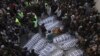 People from the Shiite Hazara community gather around the bodies of coal mine workers who were killed by unknown gunmen near the Machh coal field, in Quetta, Pakistan, Sunday, Jan. 3, 2021. 